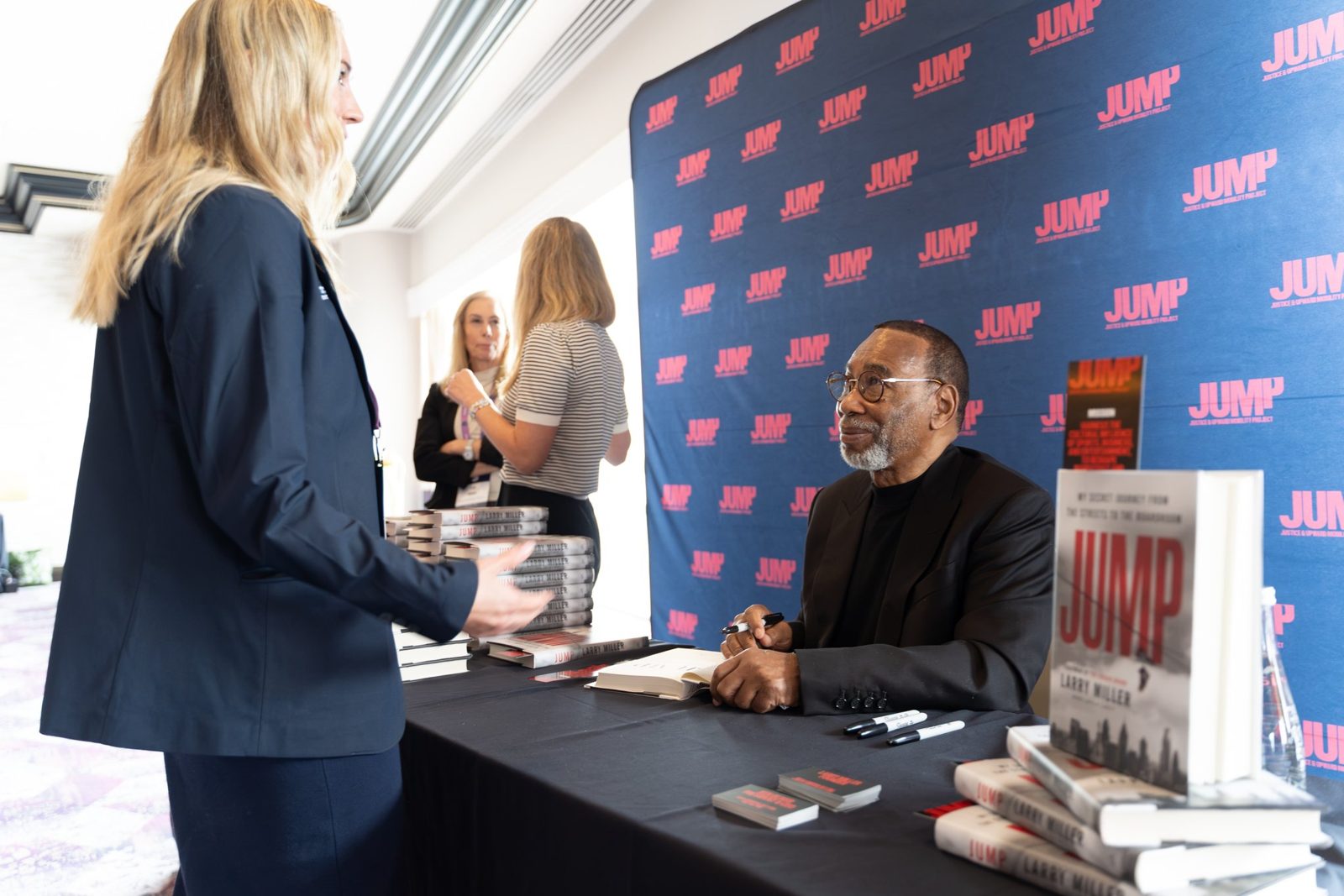 Larry Miller signing copies of his memoir JUMP for an attendee