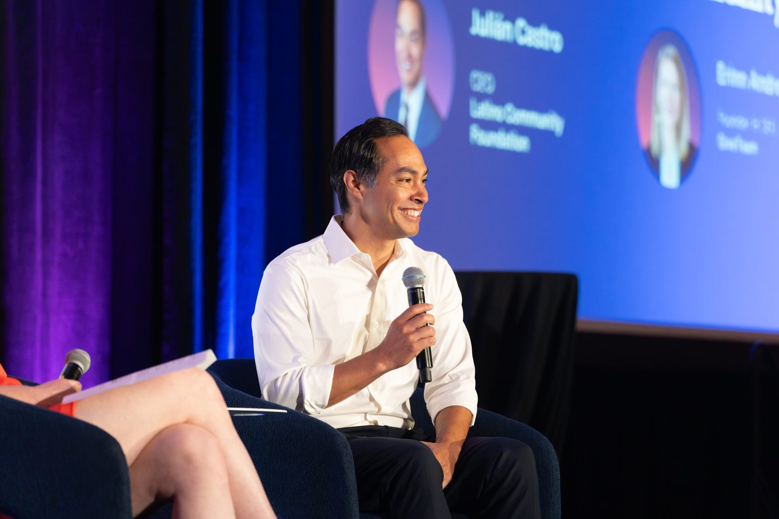 Julián Castro smiling during a fireside chat on stage